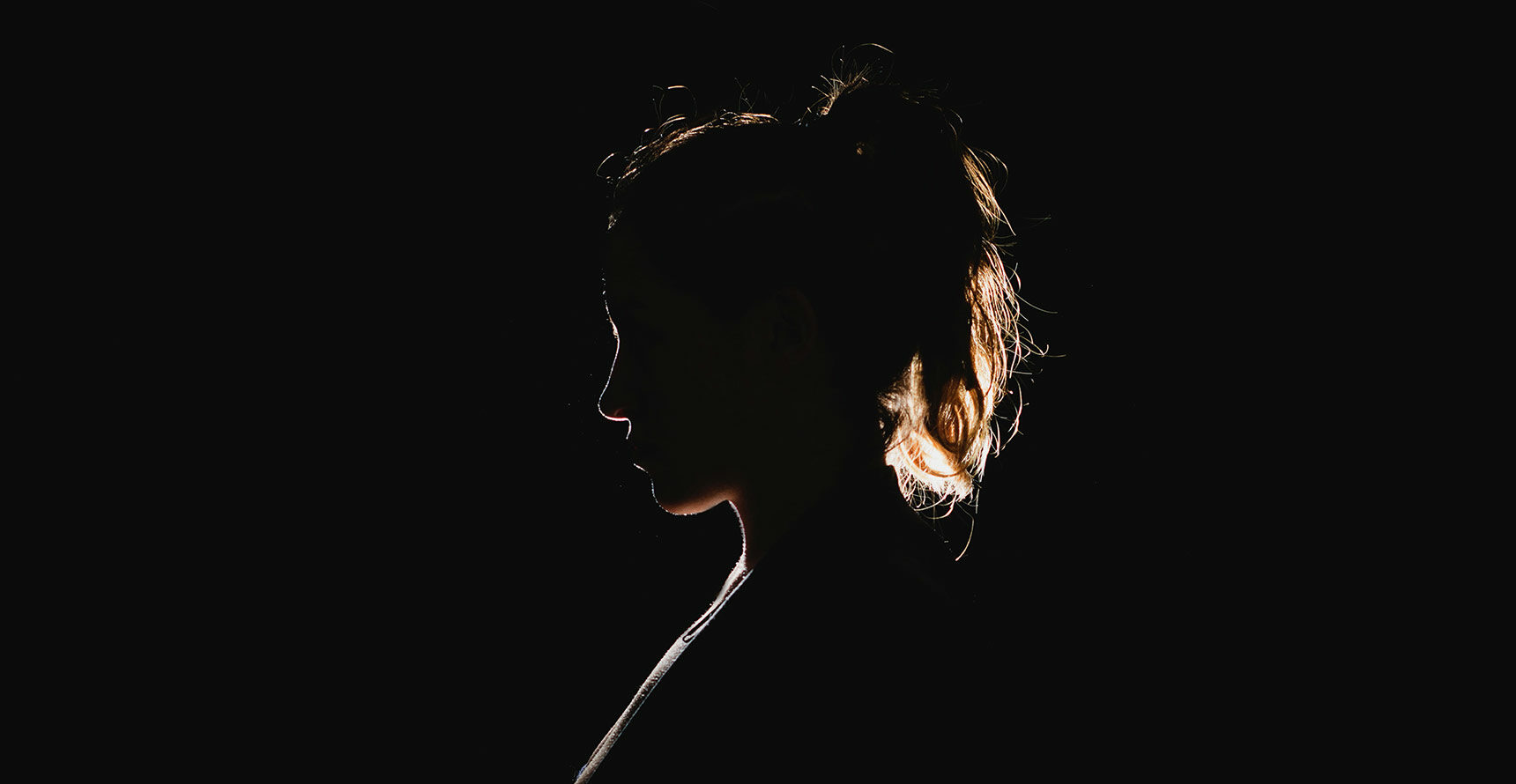 A woman's silhouette against a dark background.