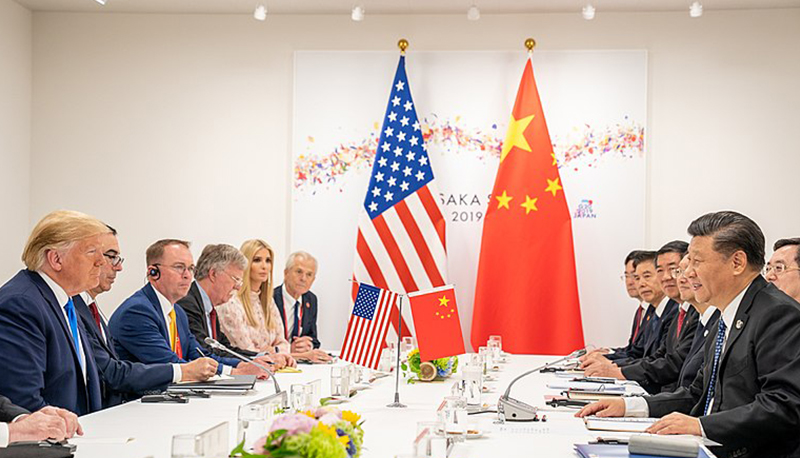 U.S. President Donald Trump sits across a table from Chinese President XI Jinping at the 2019 G20