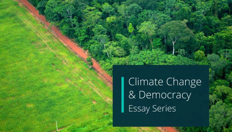 background photo of an aerial view of deforestation. Overlaid is a teal textbox with white text and reads "Climate Change & Democracy Essay Series"